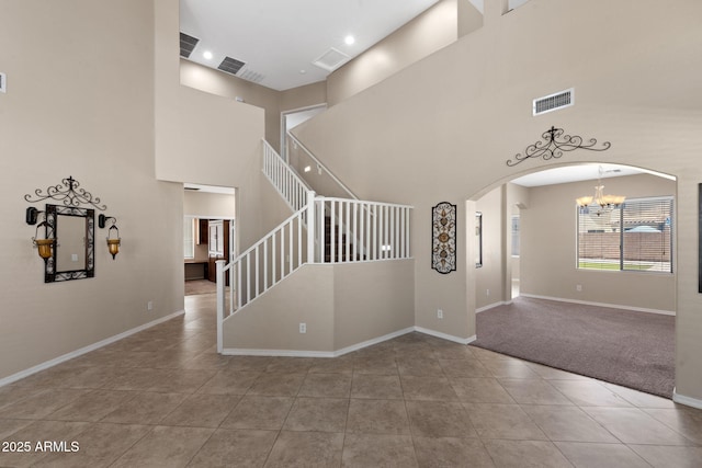 2036 E Carob Dr, Chandler, AZ 85286 - interior space with a chandelier, arched walkways, tile patterned floors, baseboards, and a towering ceiling