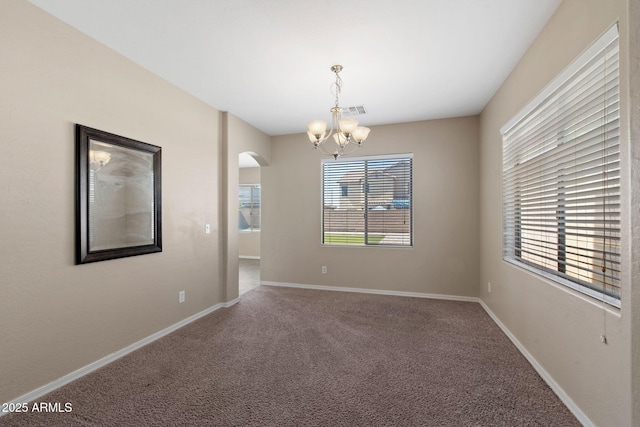 2036 E Carob Dr, Chandler, AZ 85286 - spare room with arched walkways, a chandelier, carpet floors, and baseboards