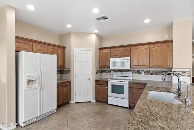 2036 E Carob Dr, Chandler, AZ 85286 - kitchen with white appliances, a sink, light stone counters, light tile patterned floors, and recessed lighting