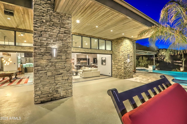 patio at twilight featuring outdoor lounge area and an outdoor pool