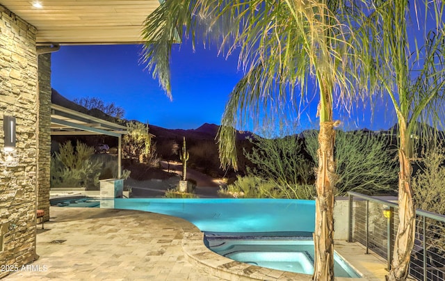 outdoor pool with a patio area and an in ground hot tub