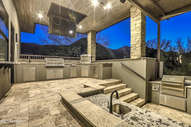 view of patio with a sink, an outdoor kitchen, and a grill