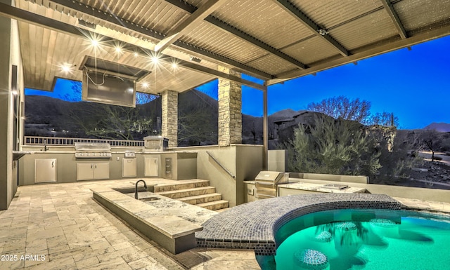 view of patio featuring exterior kitchen and a grill