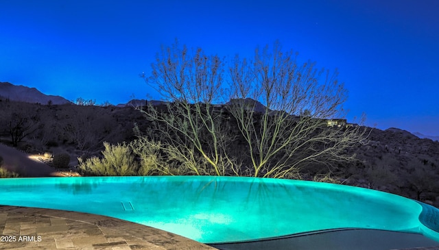 view of pool featuring an infinity pool and a mountain view