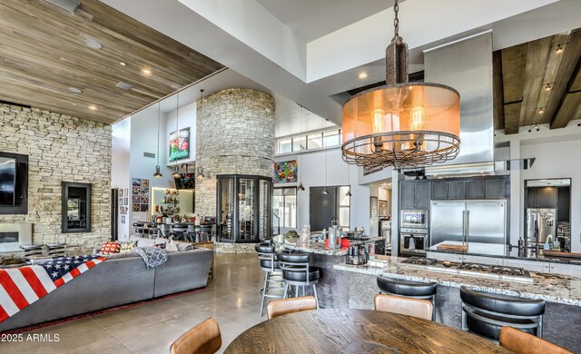 dining room with tile patterned flooring, recessed lighting, wood ceiling, a towering ceiling, and an inviting chandelier