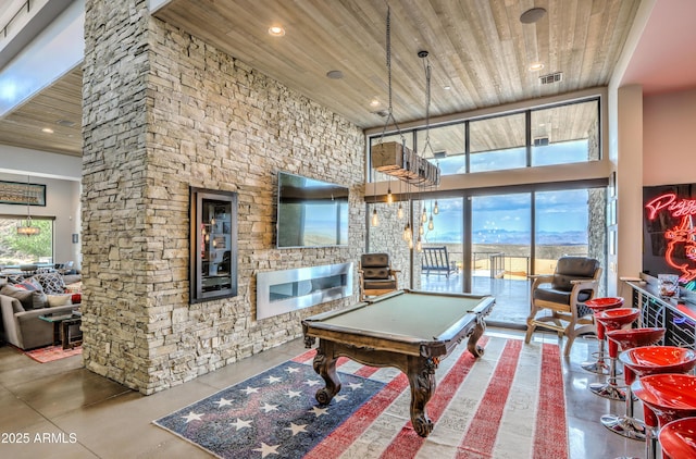 game room featuring a high ceiling, wooden ceiling, finished concrete floors, and visible vents