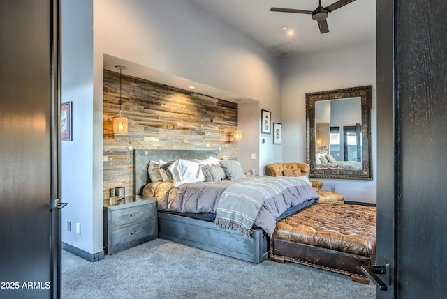 bedroom with baseboards, ceiling fan, an accent wall, carpet flooring, and wood walls