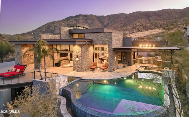 pool featuring a mountain view, outdoor dry bar, an outdoor kitchen, and a patio