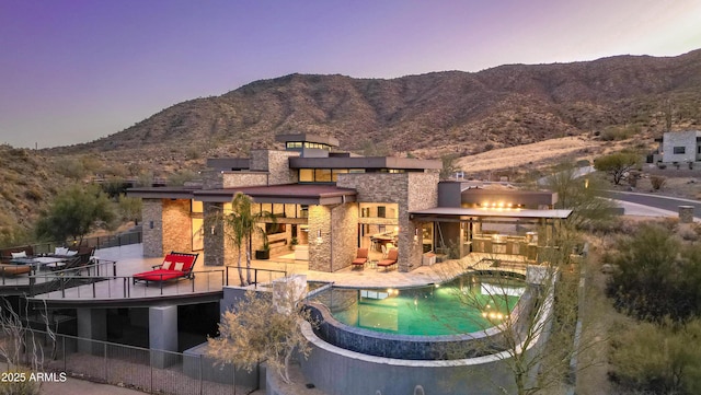 exterior space with stone siding, a patio area, a mountain view, and area for grilling