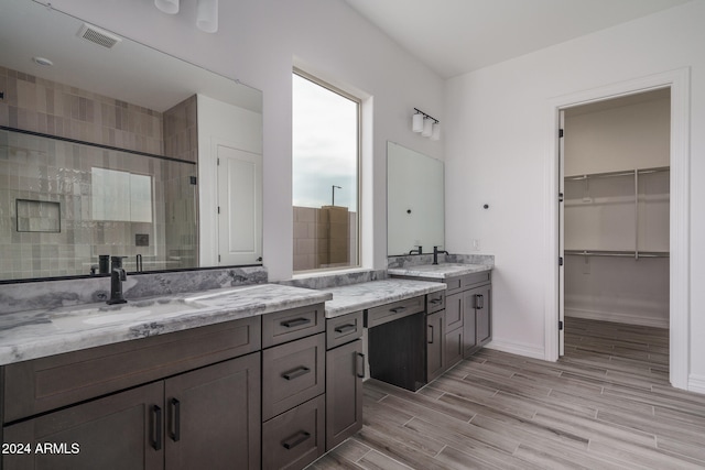 bathroom featuring a shower with door, vanity, and wood-type flooring