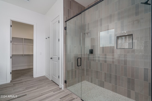 bathroom featuring wood-type flooring and an enclosed shower