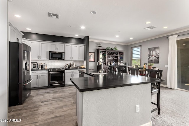 2425 W Bronco Butte Trl Unit 2028, Phoenix, AZ 85085 - kitchen featuring stainless steel appliances, a sink, dark countertops, a breakfast bar, and ornamental molding