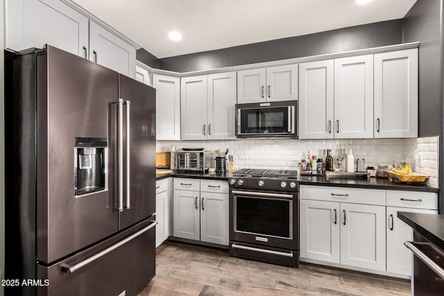 2425 W Bronco Butte Trl Unit 2028, Phoenix, AZ 85085 - kitchen with stainless steel appliances, dark countertops, decorative backsplash, light wood-style floors, and recessed lighting