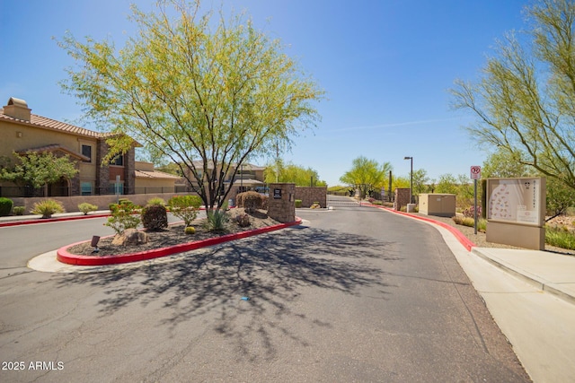 2425 W Bronco Butte Trl Unit 2028, Phoenix, AZ 85085 - view of asphalt road with curbs and a gated entry