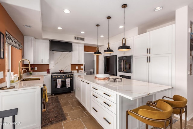 kitchen with high end appliances, a sink, recessed lighting, white cabinetry, and light stone counters