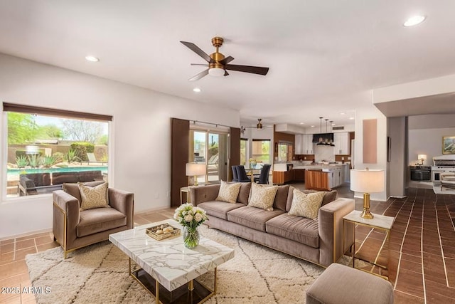 tiled living room with ceiling fan and recessed lighting