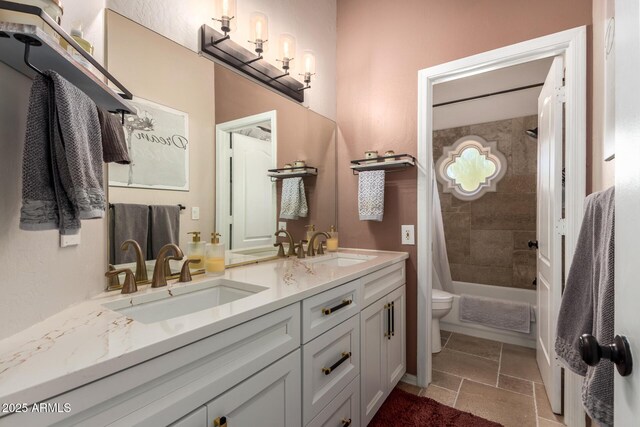 bathroom with double vanity, toilet, shower / bath combo with shower curtain, and stone tile floors
