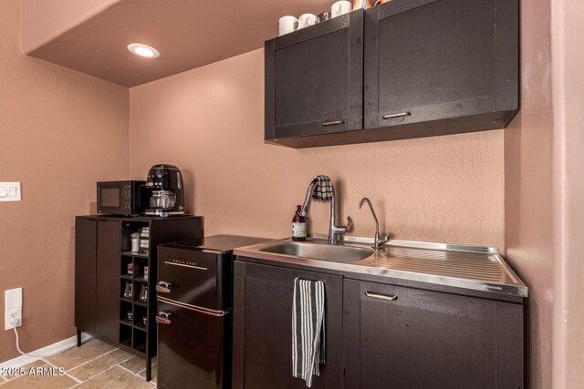 kitchen featuring a sink, baseboards, fridge, and black microwave