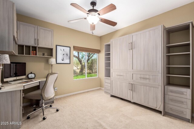 home office featuring light colored carpet, ceiling fan, and baseboards