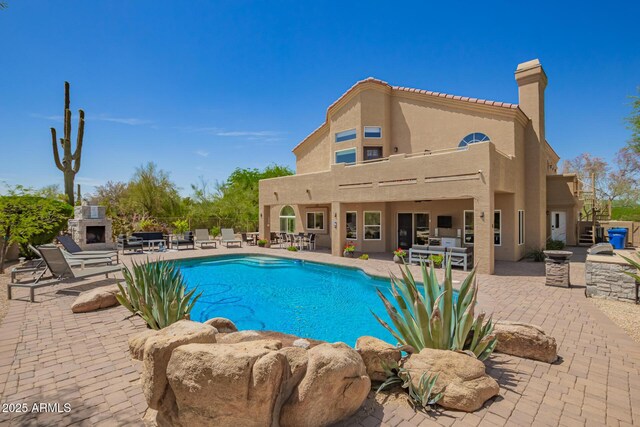 view of pool featuring a fireplace, a patio, fence, and stairs