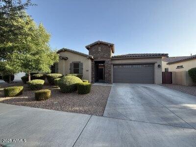 19571 E Strawberry Dr, Queen Creek, AZ 85142 - mediterranean / spanish home featuring a tile roof, stone siding, concrete driveway, stucco siding, and a garage