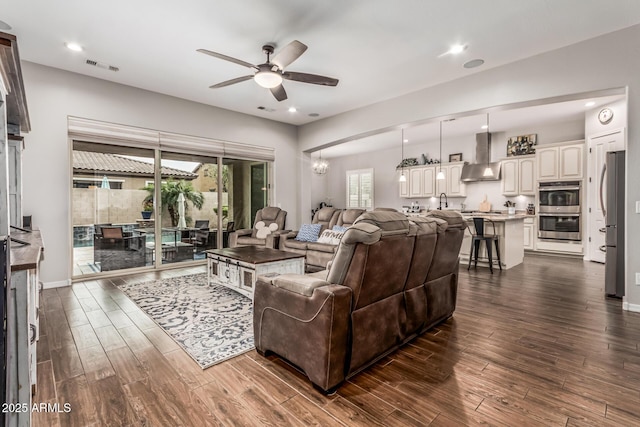 19571 E Strawberry Dr, Queen Creek, AZ 85142 - living area featuring dark wood-style flooring, visible vents, recessed lighting, and ceiling fan with notable chandelier