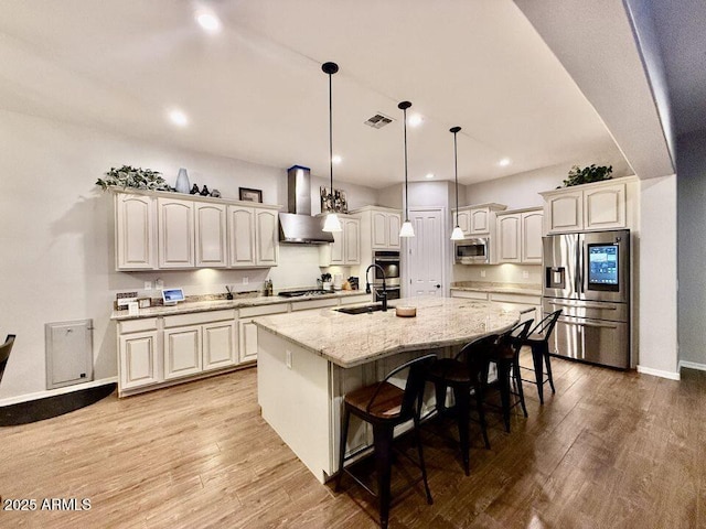 19571 E Strawberry Dr, Queen Creek, AZ 85142 - kitchen featuring a sink, wood finished floors, stainless steel appliances, wall chimney range hood, and visible vents