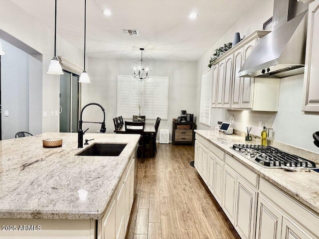 19571 E Strawberry Dr, Queen Creek, AZ 85142 - kitchen with stainless steel gas cooktop, wall chimney exhaust hood, a sink, visible vents, and wood finished floors