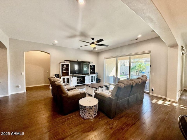 19571 E Strawberry Dr, Queen Creek, AZ 85142 - living room featuring dark wood-style flooring, visible vents, baseboards, a ceiling fan, and arched walkways
