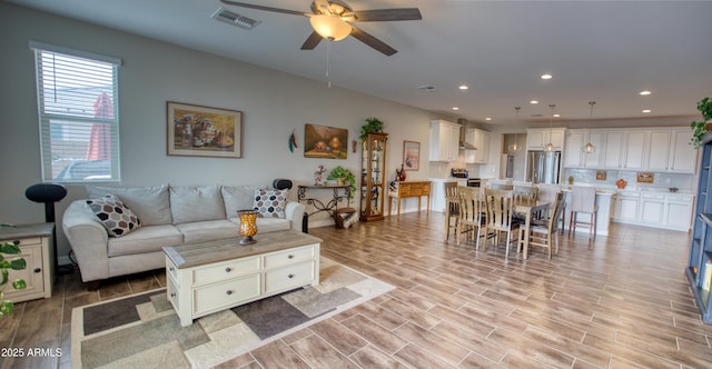 living room featuring wood finish floors, recessed lighting, visible vents, and ceiling fan