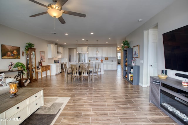 living area with recessed lighting, ceiling fan, and wood tiled floor