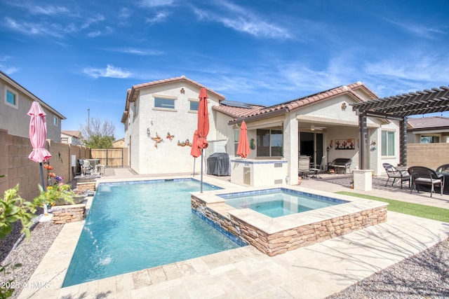 back of property featuring a patio, an in ground hot tub, a fenced backyard, and a tiled roof