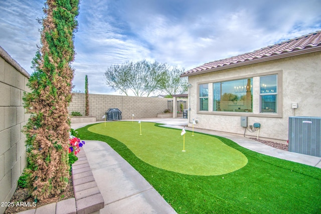 view of yard with central AC unit and a fenced backyard