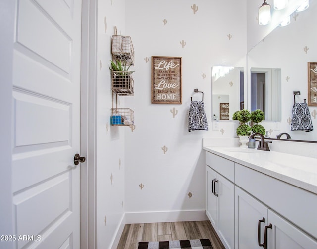 bathroom featuring vanity, baseboards, and wood finished floors