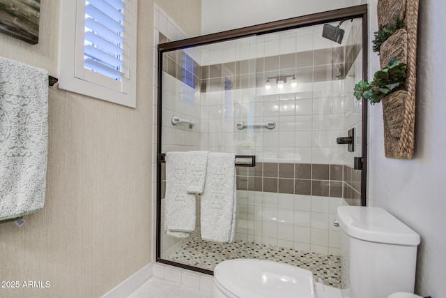 bathroom with a shower stall and toilet