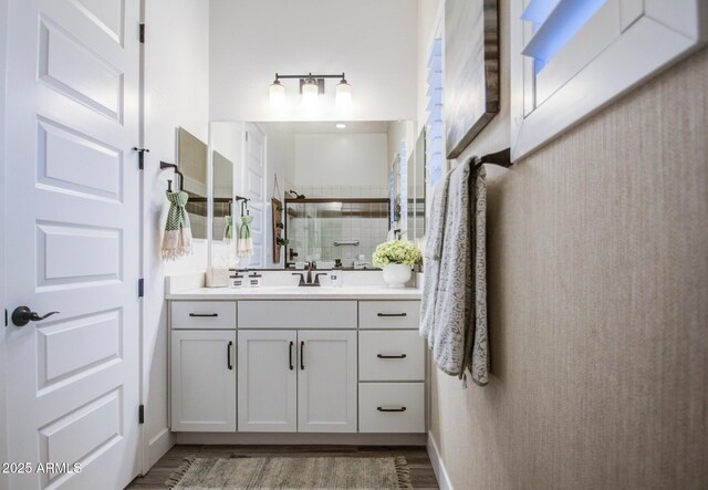 bathroom with a shower stall, vanity, and wood finished floors