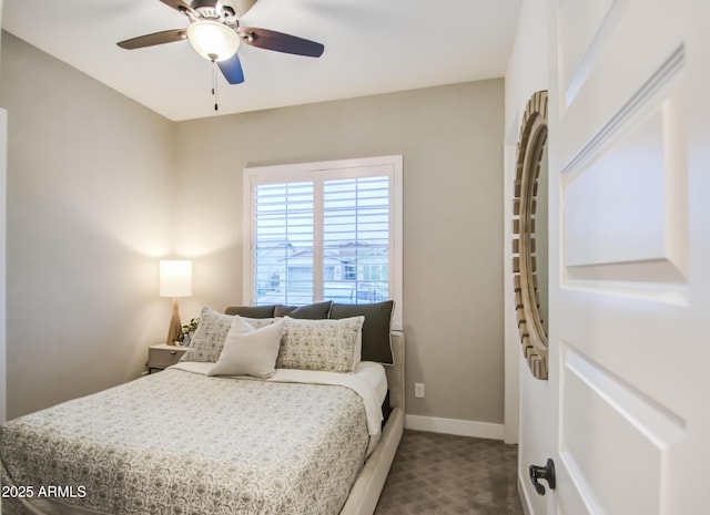 bedroom with a ceiling fan, baseboards, and dark carpet