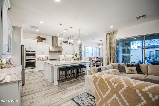 living area featuring recessed lighting, visible vents, and light wood-style flooring