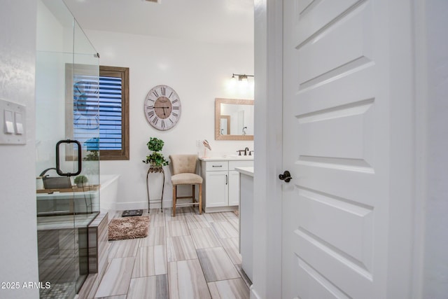 full bathroom featuring vanity, a soaking tub, baseboards, and a shower stall