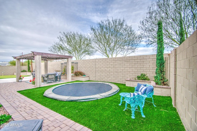 view of yard featuring a patio, a trampoline, a fenced backyard, and a pergola