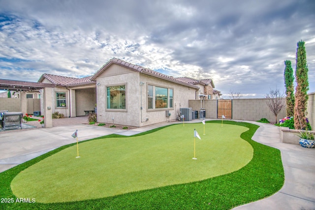 back of property featuring a tiled roof, central AC unit, stucco siding, a fenced backyard, and a patio