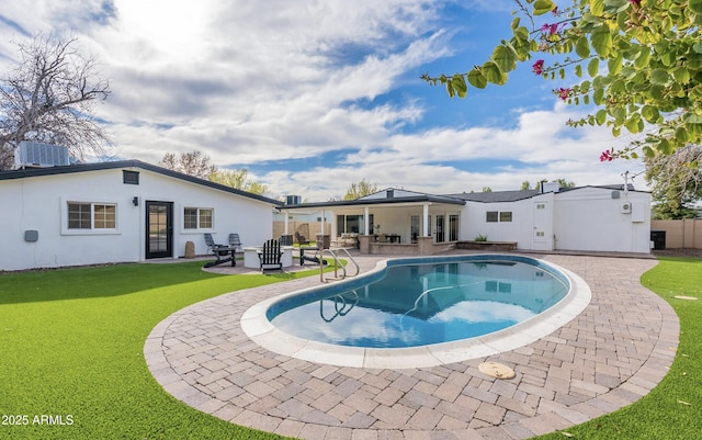 view of pool with a patio area and a lawn