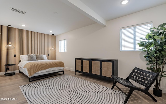 bedroom featuring light wood-type flooring and beam ceiling