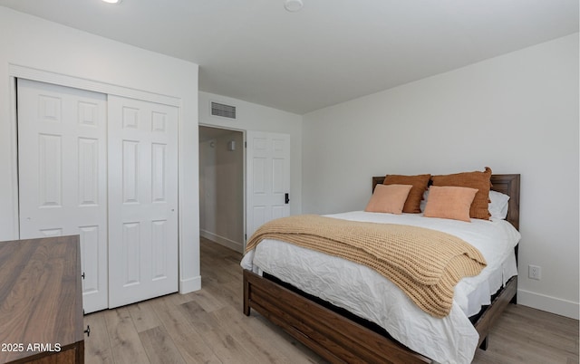 bedroom with light hardwood / wood-style floors and a closet