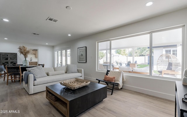 living room with a wealth of natural light and light hardwood / wood-style flooring