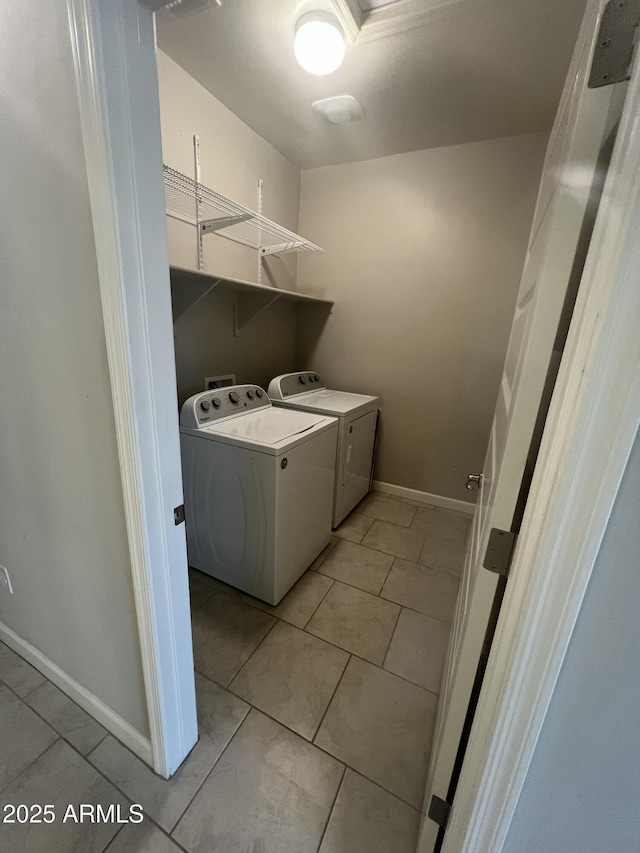 washroom featuring washer and clothes dryer and light tile patterned floors