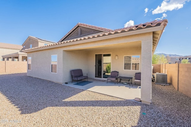 rear view of house with a patio, a mountain view, and central AC