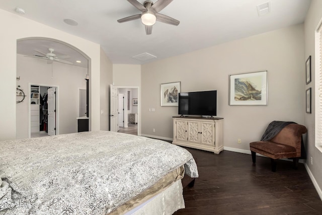 bedroom with dark wood-type flooring, ceiling fan, and a spacious closet