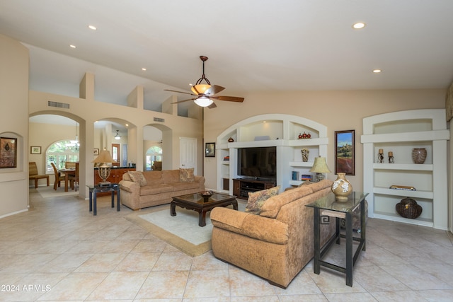 tiled living room with built in features, ceiling fan, and vaulted ceiling