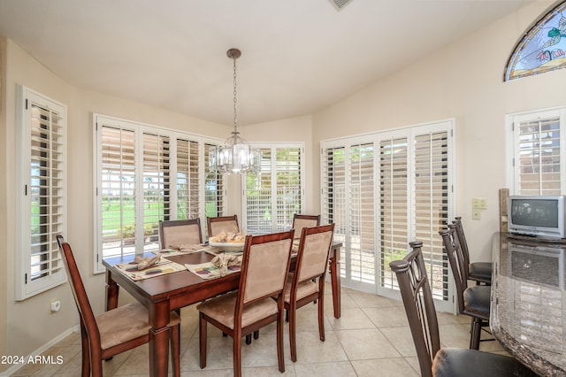 dining area with vaulted ceiling, light tile patterned floors, and a notable chandelier